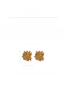 Macro detail of gold flower stud earrings featuring clear rhinestones and silver needle