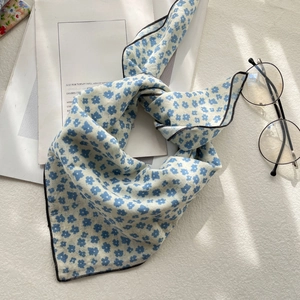 Detailed view of cream square scarf with blue floral pattern and retro black edges