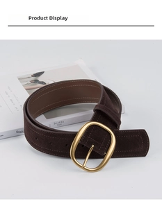Détail d'une large ceinture en daim marron foncé avec boucle ardillon ovale dorée