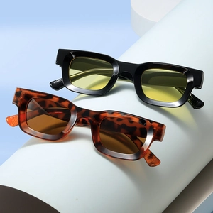Chic thick-frame square sunglasses in black and tortoiseshell finish on blue stands