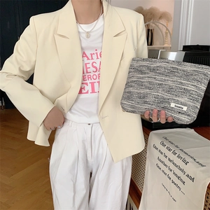 Neceser de tweed con textura de mariposa de gran capacidad mostrado por una modelo