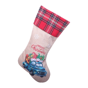 Linen Christmas stocking with blue truck gnome design and red plaid cuff on white background