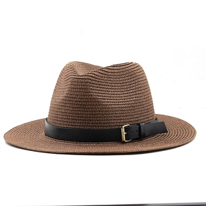 Détail du chapeau fedora en paille marron avec bande en cuir noir et boucle dorée