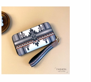 Detail of bohemian geometric print on long zipper wallet with a matching wrist strap