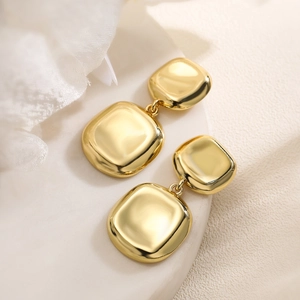 Minimalist gold-plated double square geometric earrings on a white elegant pedestal