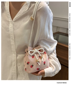 Dettaglio borsa a secchiello in velluto rosa a fragole con coulisse bianca e perle oro