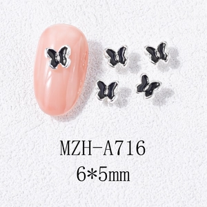 Vue macro de breloques à ongles papillon 3D émail noir 6x5mm sur une base en argent