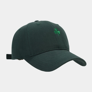 Détail de la broderie trèfle sur une casquette de baseball en coton vert foncé avec sangle réglable