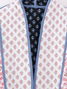 Detail of reversible quilted floral jacket showing dual-pattern design and blue binding