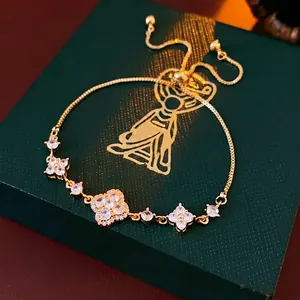 Gold-plated adjustable flower bracelet with sparkling zircons on a green velvet box