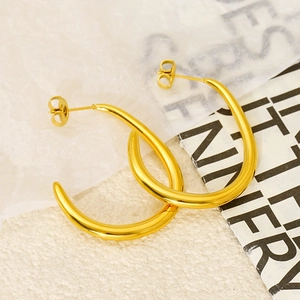 Polished 18k gold plated stainless steel C-shaped hoop earrings on minimalist background