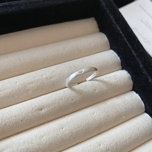 Detailed view of silver matte finish ring with heart patterns in a velvet jewelry box