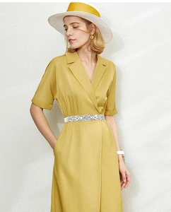 Detail of elegant white rhinestone elastic belt paired with a yellow wrap dress