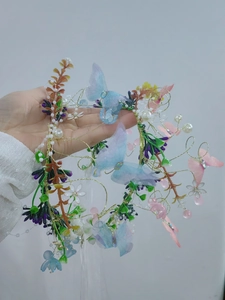 Detail of floral crown headband with organza butterflies, purple flowers and pearls