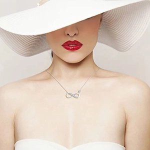 Close-up of infinity symbol pendant with pavé stones on a delicate silver chain