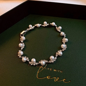 Bracelet élégant en perles d'eau douce blanches et strass sur fond de velours vert