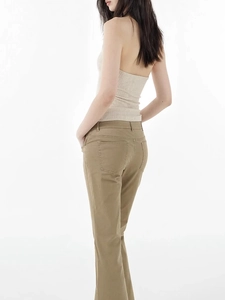 Detail of a beige knitted halter top with cross V-neck and open back on a female model