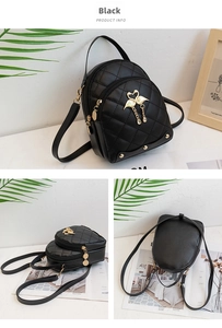 Detail view of mini black quilted backpack featuring golden swan charms and dual zippers