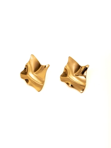 Close-up of golden irregular geometric textured wave studs with metallic finish