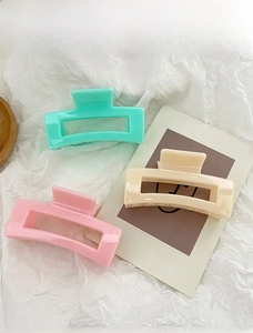 Three hollow square hair claws in mint green, pastel pink, and cream on a white background