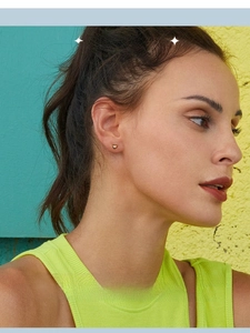 Close-up of a model wearing a mini gold heart stud earring made of S925 sterling silver