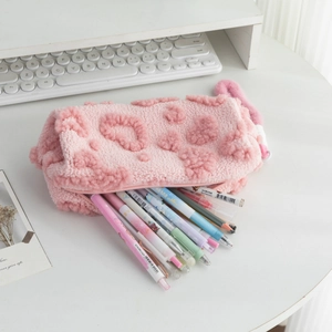 Detail view of large capacity pink plush pencil case with floral decor and stationery