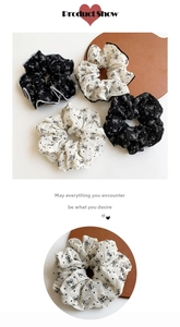 Detailed view of polka dot bow scrunchies with crinkled fabric texture on wooden tray