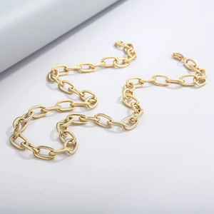 Detailed view of golden titanium steel chain with textured oval links on white background