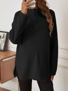 Detail of black fleece maternity sweatshirt with half-zip and side slits on casual long sleeve