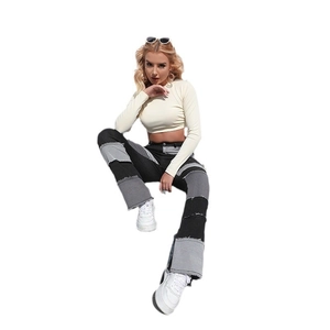 Détail du jean évasé slim à taille haute avec patchwork noir et gris et ourlets effilochés
