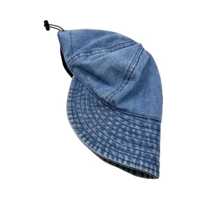 Detail of blue denim bucket hat with wide brim, reinforced stitching, and adjustable cord