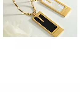 Detailed shot of rectangular gold pendants with black enamel and white mother of pearl