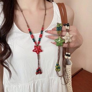 Detail of colorful ceramic starfish pendant necklaces with braided wax cord and tassels