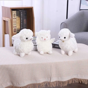 Three cute white plush lamb toys with bells in a cozy home setting, perfect for kids