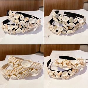 Detail view showing four baroque headbands with pearls and seashells in a natural style