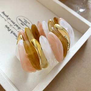 Detail of acrylic oval marbled beads and metallic gold accents on a chic bracelet