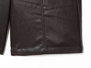 Close-up of deep brown faux leather shorts showing lychee texture and stitching detail