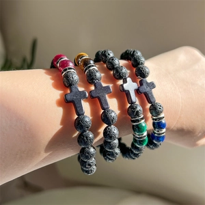 Detail of four matte lava stone beaded bracelets with colorful tiger eye and cross charms