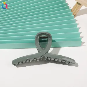 Detail view of large sage green glossy hair claw clip with cross-twist design