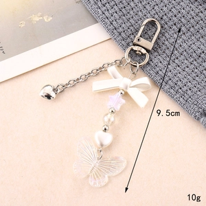 Detail view of 9.5cm acrylic bow keychain with iridescent butterfly pendant and charms