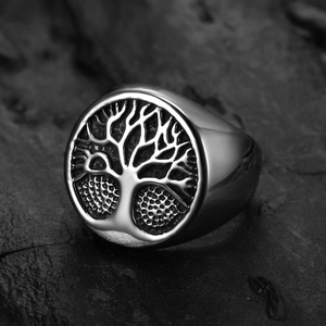 Vintage stainless steel Tree of Life ring in silver and black finish on a dark rock surface