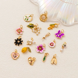 DIY 18K gold plated charms with floral, fruit and heart shapes on beige texture