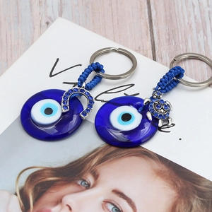 Blue Evil Eye keychain set with horseshoe and turtle charms on magazine background