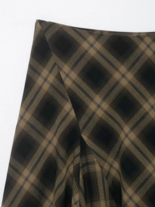 Détail de la texture du tissu à carreaux marron et noir sur une jupe en dentelle
