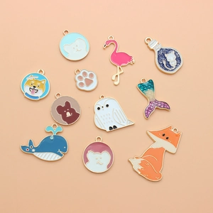 Flat lay of colorful enamel animal charms for DIY jewelry making in various shapes