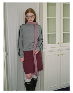 Detail of pink knitted scarf paired with grey sweatshirt and burgundy skirt outfit
