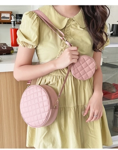 Pink quilted round crossbody bag and matching mini coin purse shown on a model