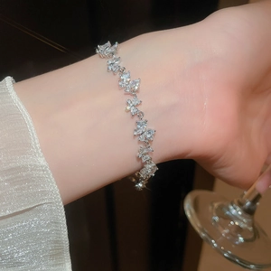 Detailed view of silver butterfly bracelet with sparkling cubic zirconia on a model's wrist