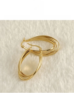 Detail of 18k gold plated triple-hoop earrings on white fur background texture