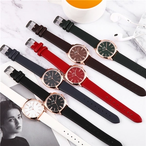 Flat lay of multiple leather strap square watches with rose gold cases in seven colors